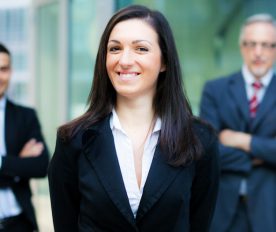 Business woman in foreground with two businessmen behind her